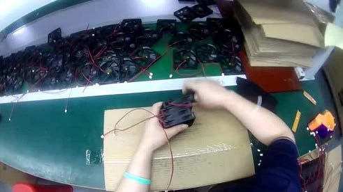 First-person view of hands sorting components and cables into packaging